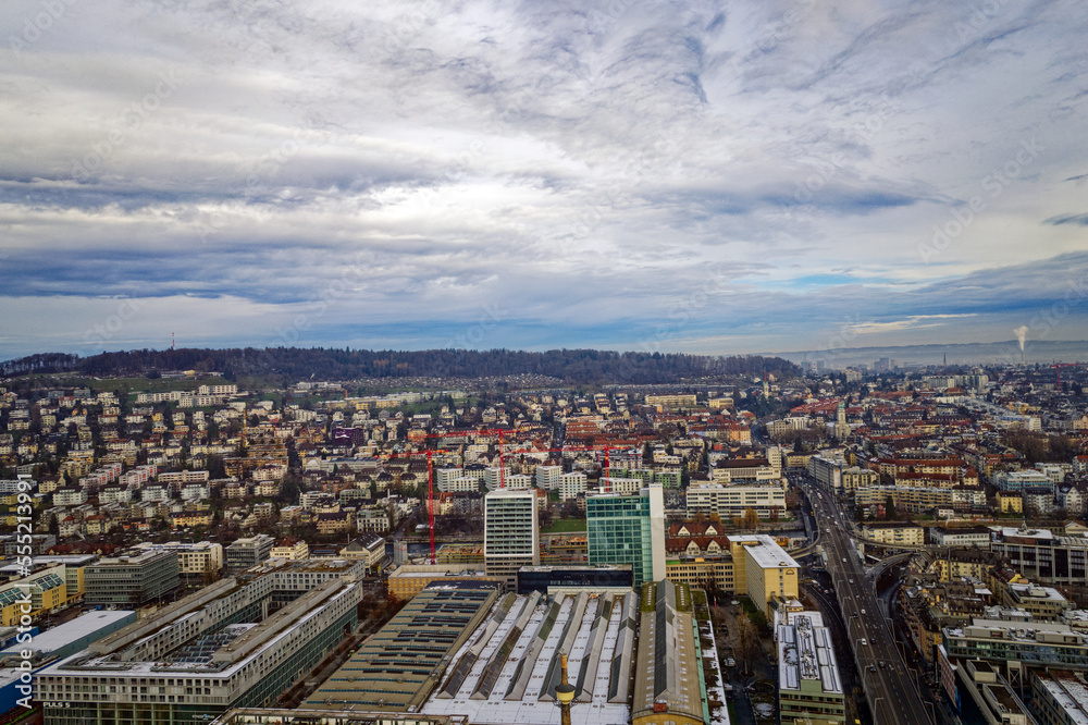 Obraz premium Aerial view of City of Zürich seen from industrial district with Waidberg and Käferberg in the background on a cloudy winter day. Photo taken December 20th, 2022, Zurich, Switzerland.