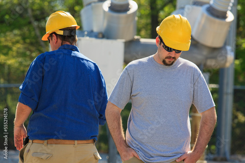 Power engineers at high voltage power distribution station photo