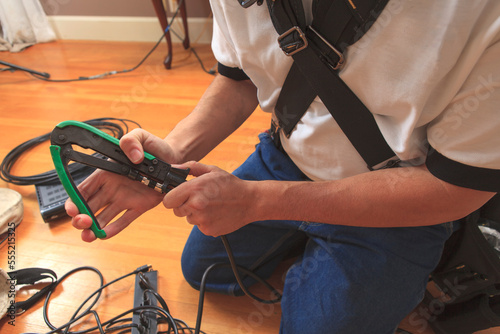 Cable installer using a crimping tool to add a new cable connector to a cable photo