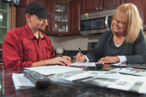Cable installer doing contract paperwork with home owner photo