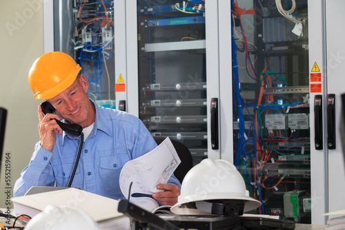 Electrical engineer reviewing process diagrams in operations room of electric power plant photo