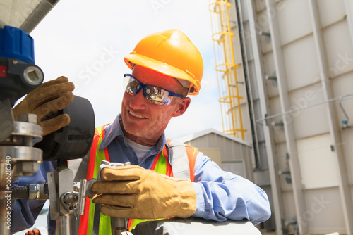 Engineer examining transducer gauge at electric power plant photo