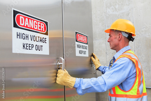Engineer at electric power plant opening high voltage area doors