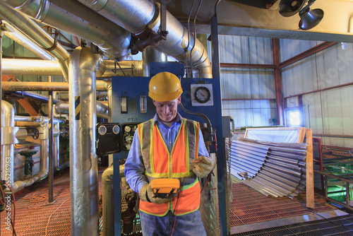 Engineer in electric power plant using a voltmeter to verify sensor readings