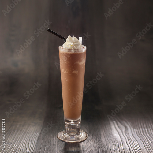 Chocolate Milkshake with straw served in glass isolated on table side view healthy morning drink