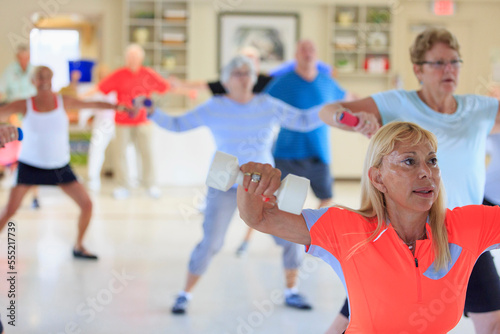 Female instructor leading a senior's fitness class photo