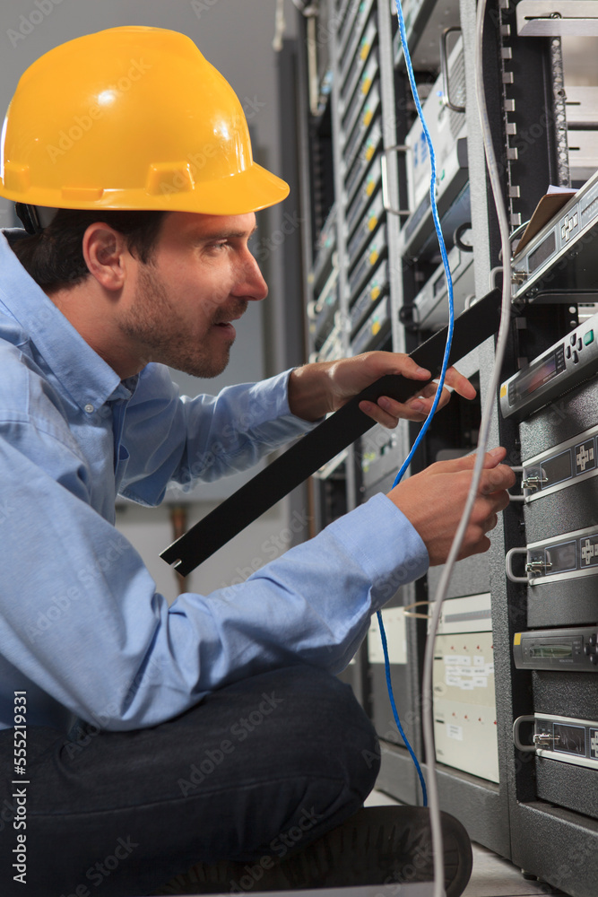 Network engineer installing faceplate in a rack Network engineer installing faceplate in a rack