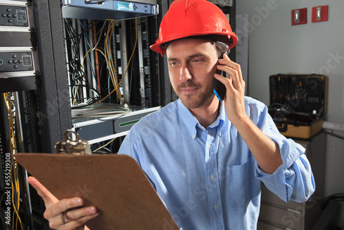 Network engineer on phone performing trouble shooting photo