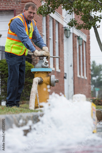 Water department technician opening fire hydrant to flush water mains