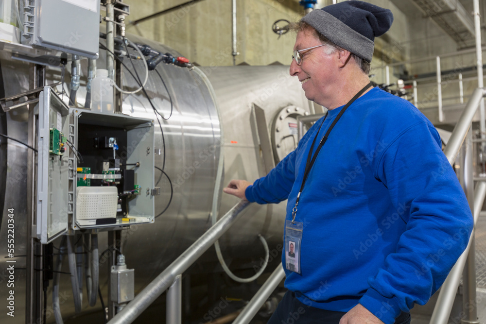 Man checking circuit box on equipment in industrial workplace Man checking circuit box on equipment in industrial workplace