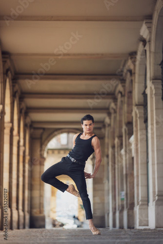 Fototapeta Naklejka Na Ścianę i Meble -  Young man dancing classic ballet in the streets of Barcelona with a beautiful background and light