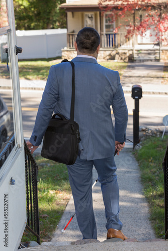 Businessman with Visual Impairment going outside with his cane photo