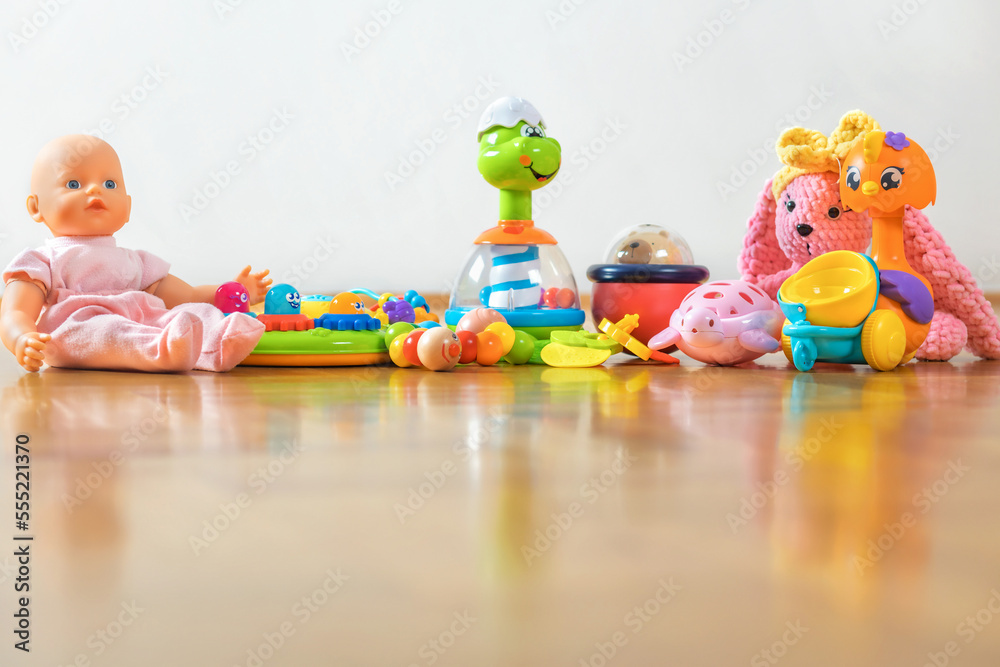 Various kids toys on a wooden parquet floor with copy space