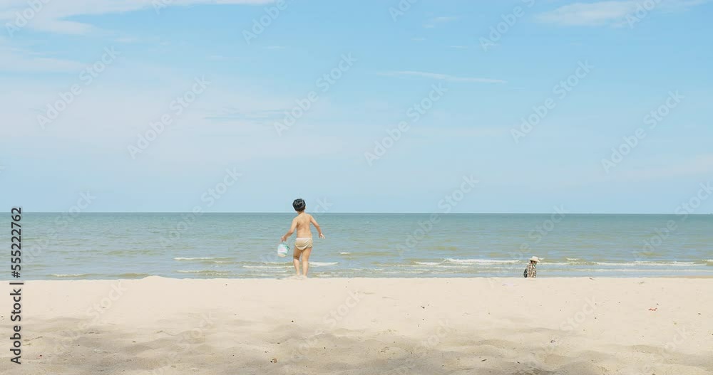 active happy cute Asian children boy enjoy leisure summer vacation holiday travel walking on tropical ocean sea beach and playing sand on sunny day blue sky background active happy cute Asian children boy enjoy leisure summer vacation holiday travel walking on tropical ocean sea beach and playing sand on sunny day blue sky background