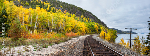 Train tracks along Lake Superior with tree in autumn coloured foliage; Ontario, Canada
