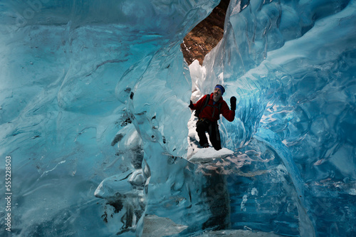 A hiker explores an ice cave recently revealed at Mendenhall Glacier, Alaska, USA