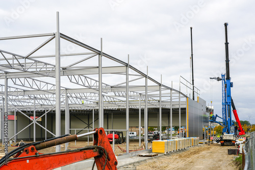 Фотография Sandwich panel wall assembly on an assembled steel frame of a new warehouse buil