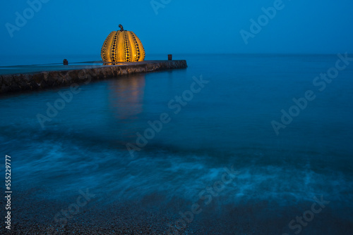 The Naoshima Pumpkin illuminated at the end of the pier, Naoshima Island, Seto Inland Sea, Japan photo