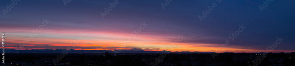 Mount Baker viewed in the distance along the dark horizon and glowing sky at sunset, viewed from Surrey, BC; Surrey, British Columbia, Canada Mount Baker viewed in the distance along the dark horizon and glowing sky at sunset, viewed from Surrey, BC; Surrey, British Columbia, Canada