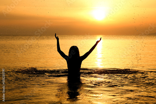 A happy girl in the sea on nature travel silhouette