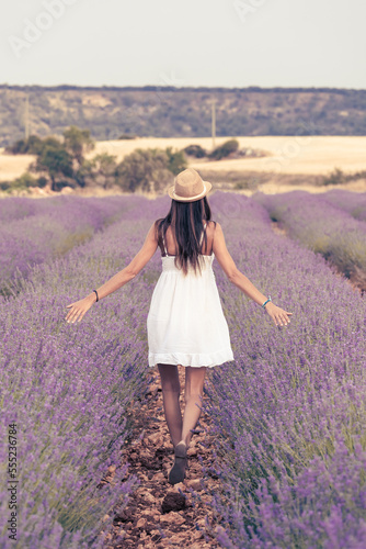 woman in white dress walking through a lavender field