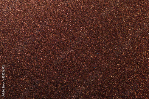 Background with sparkles. Backdrop with glitter. Shiny textured surface. Very dark red