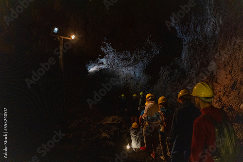Group exploring a volcanic cave in the Volcanic Caves Park at the foot of Villarrica volcano in Pucon, Chile 