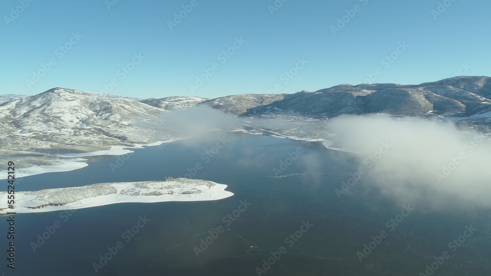Fototapeta premium Aerial of low clouds over Jordanelle Rservoir in Park City on sunny winter day