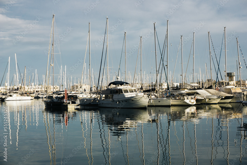 Harbour background. Many sailboats background. Expensive yachts in port. Seashore vacation landscape. Beautiful evening view. Sunrise in sea marina. Water reflection dock. Outdoor ships by the bay. 