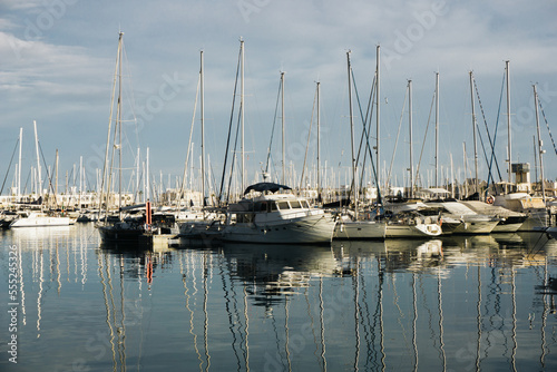 Harbour background. Many sailboats background. Expensive yachts in port. Seashore vacation landscape. Beautiful evening view. Sunrise in sea marina. Water reflection dock. Outdoor ships by the bay. 
