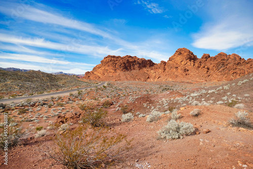 Road through the arid desert with red sandstone formations in Valley of Fire State Park, Nevada, USA 