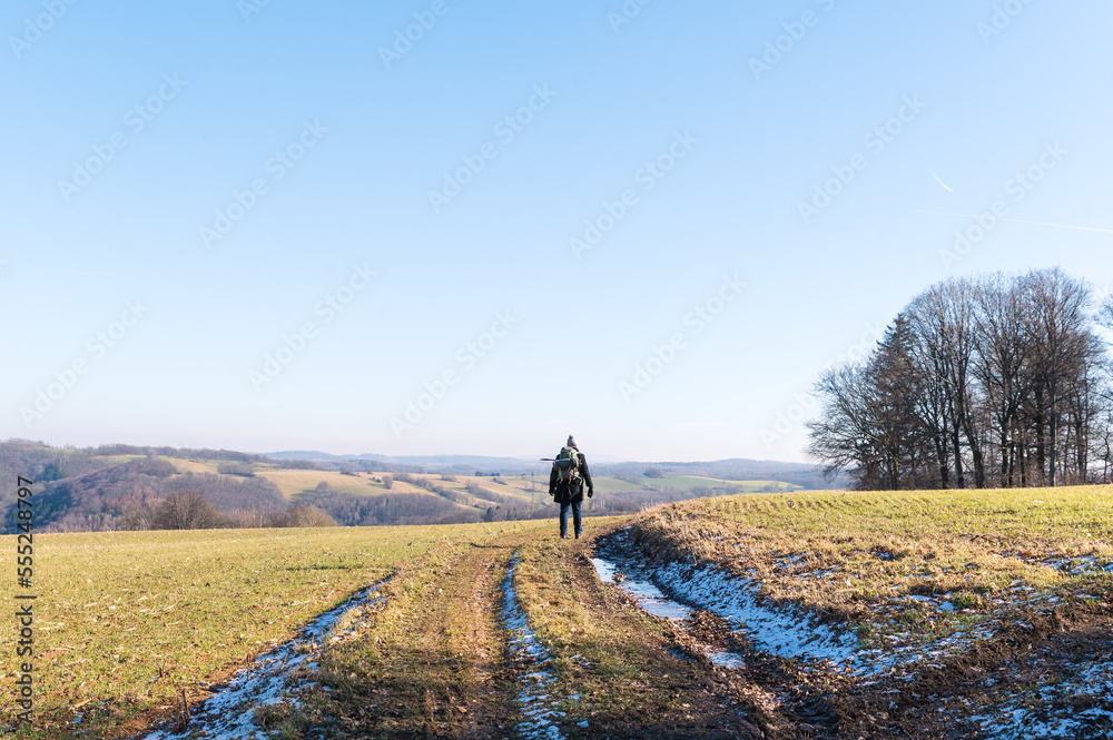 man walking on trail in winter man walking on trail in winter