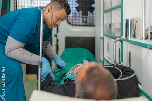 Doctor measuring the pressure of a patient in an ambulance photo