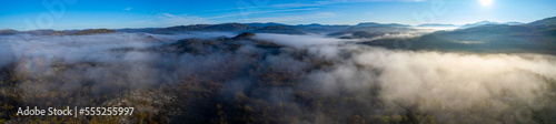 Aerial view around foggy mountain top in Montenegro on an early sunny morning in autumn.