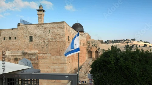the old city in Jerusalem with a view of the Israeli flag fluttering in the wind above the entrance to the wailing wall photo