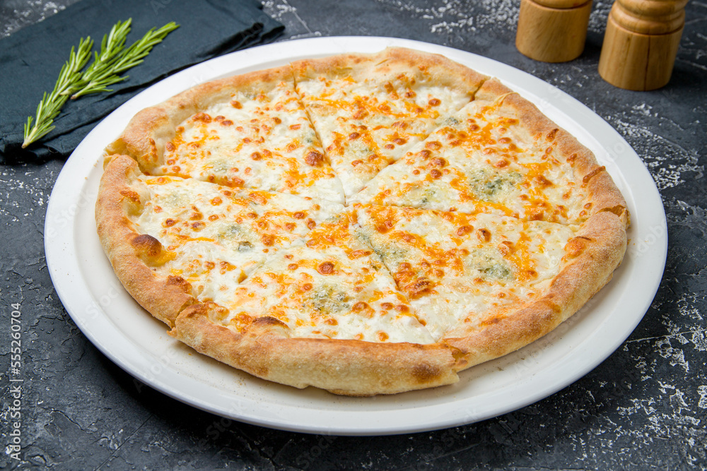 Pizza Quattro formaggi on black table side view Pizza Quattro formaggi on black table side view
