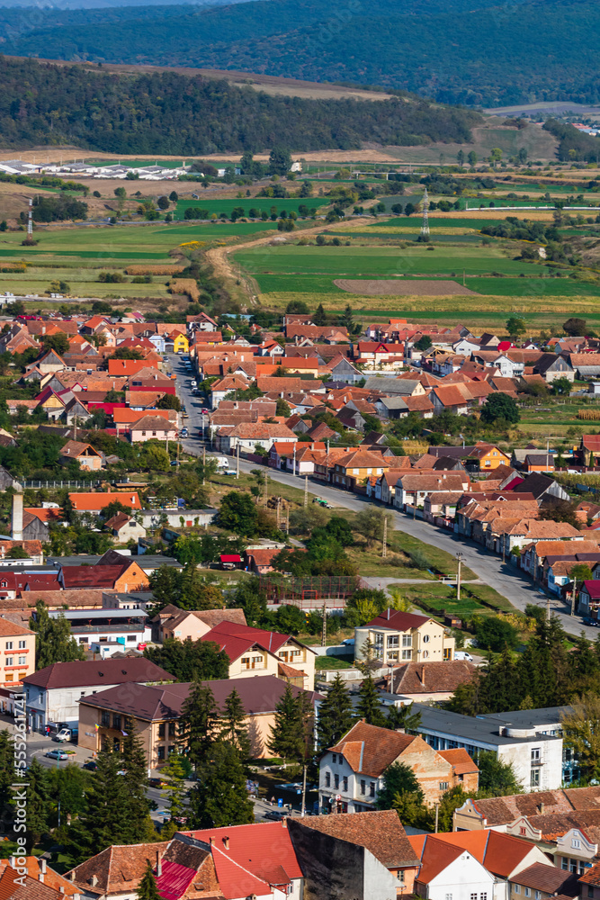 Aerial view of the town center with hills, buildings, streets, vegetation and surroundings in Rupea, Romania, 2021