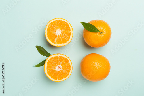 Flat lay with fresh oranges and leaves on color background
