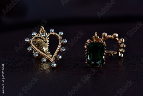 Gold earrings decorated with green gems. that shines beautifully