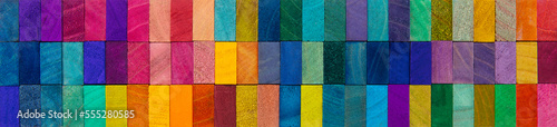 Header image or cover image for something creative or diverse. Wide format background of wooden blocks. A Spectrum of multi-colored wooden blocks aligned. 