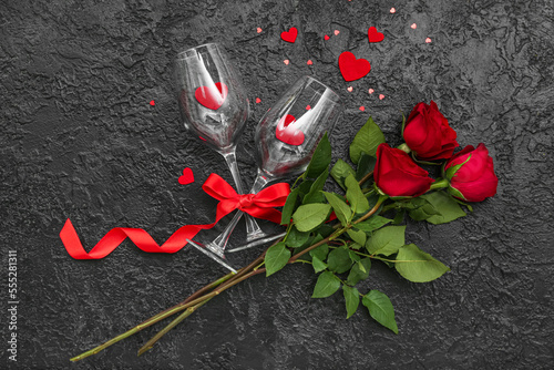 Glasses with hearts and roses on dark background. Valentine's Day celebration