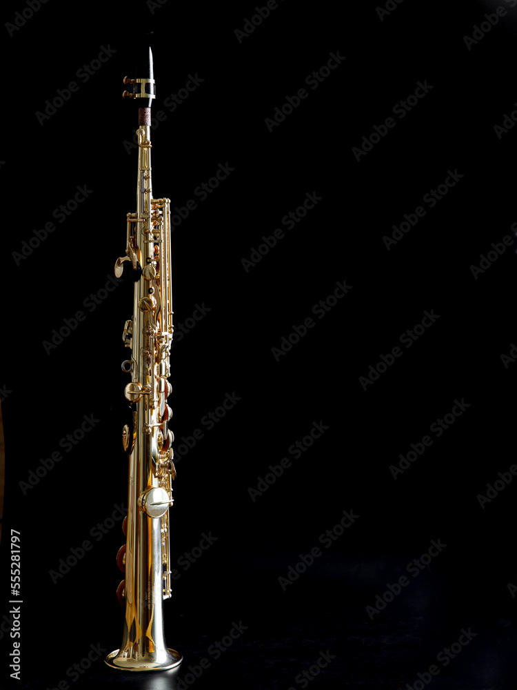 Soprano Sax, wind instrument saxophone staying on a black background, vertical, copy space. Soprano Sax, wind instrument saxophone staying on a black background, vertical, copy space.