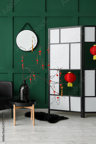 Interior of living room with tree branches in vase and decor for Chinese New Year celebration