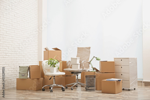 Moving boxes and stuff near white brick wall in room © New Africa