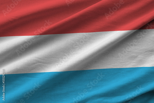 Luxembourg flag with big folds waving close up under the studio light indoors. The official symbols and colors in fabric banner photo