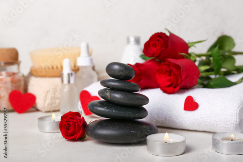 Beautiful spa composition for Valentine s Day with rose flowers  candles and stones on table