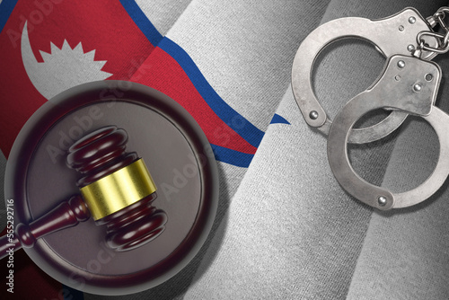 Nepal flag with judge mallet and handcuffs in dark room. Concept of criminal and punishment, background for guilty topics photo