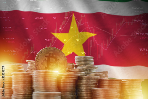 Suriname flag and big amount of golden bitcoin coins and trading platform chart. Crypto currency concept photo