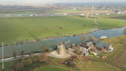 Drone flying away from historical windmill in Rural Holland photo