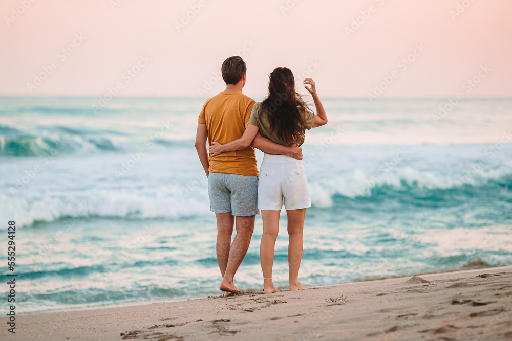 Young couple on the beach vacation in Florida at sunset Young couple on the beach vacation in Florida at sunset